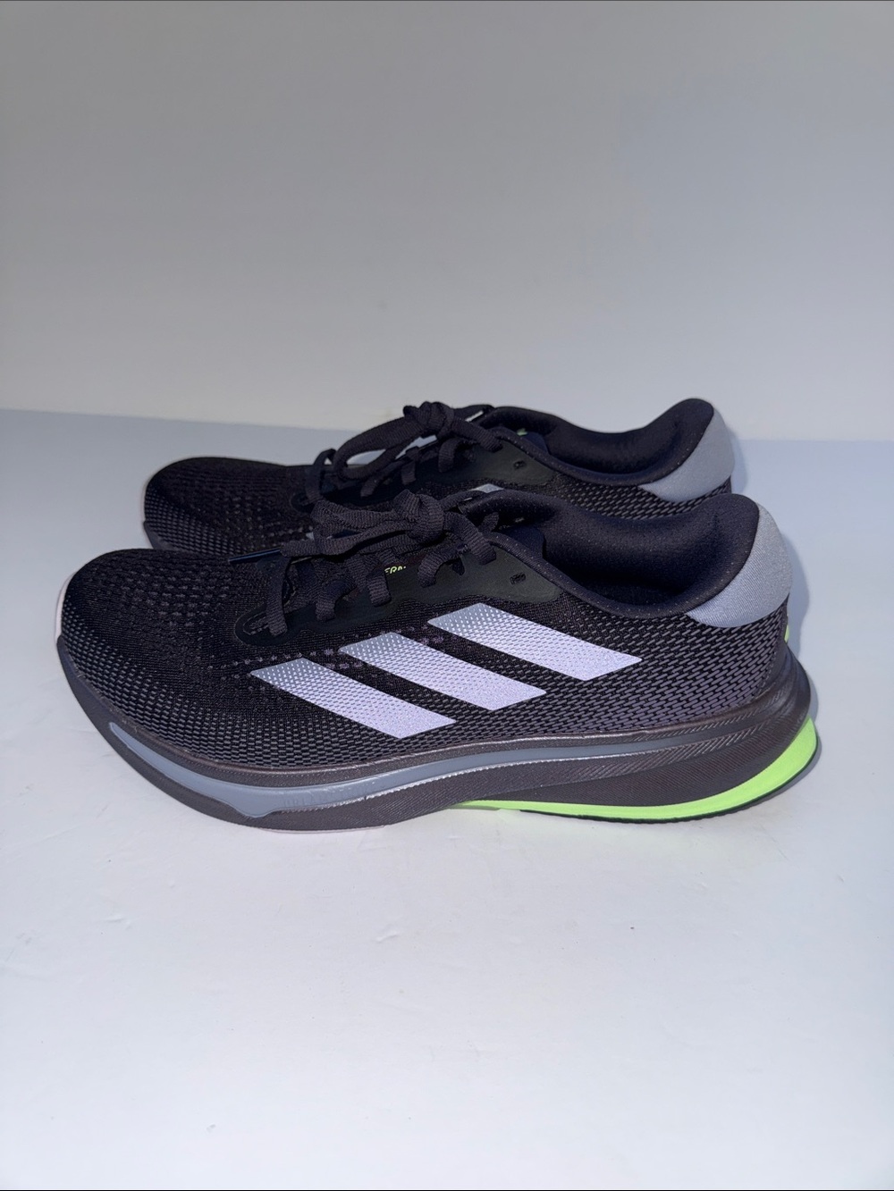 adidas women’s Black Athletic Shoes with White Stripes and Neon Green Accent